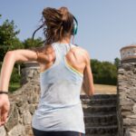 Female jogger with headphones on stairs