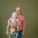Kid posing with human anatomy model