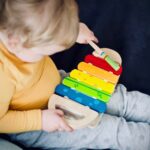 Toddler with wooden xylophone toy