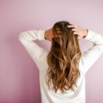 Female in white sweater touching hair