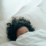 Curly-haired kid resting in bed