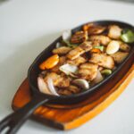 Sizzling platter with grilled meat and vegetables