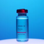COVID-19 vaccine vial on blue background