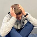 Person sitting with head in hands