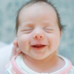Smiling newborn wrapped in a blanket