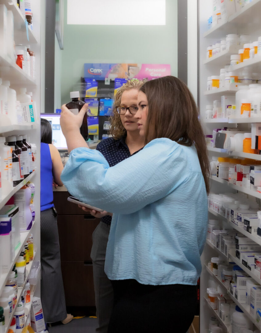 Two pharmacists looking at a medication bottle.