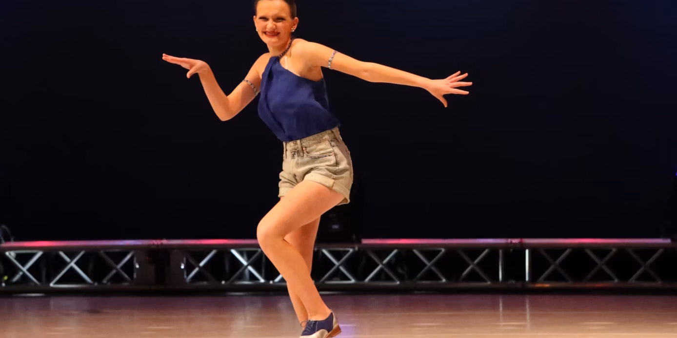 Tap dancer performing in a blue top