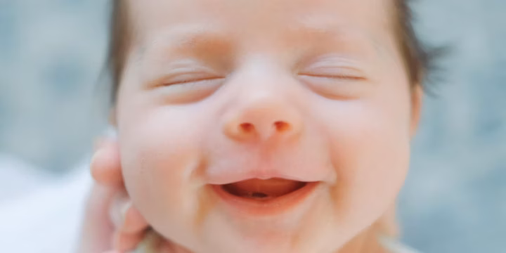 Smiling newborn wrapped in a blanket